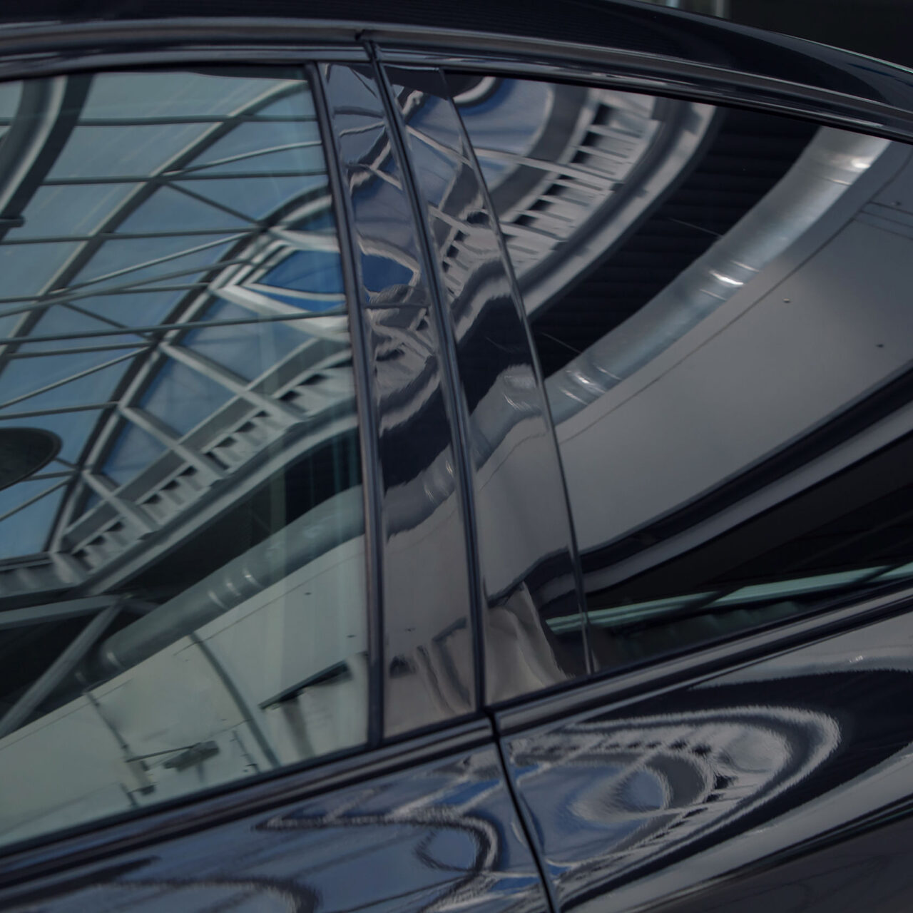 Tinted black car Windows that reflect the glass ceiling